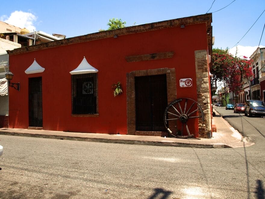 sebuah bangunan kolonial bercat merah di kota kolonial dengan roda kayu di temboknya