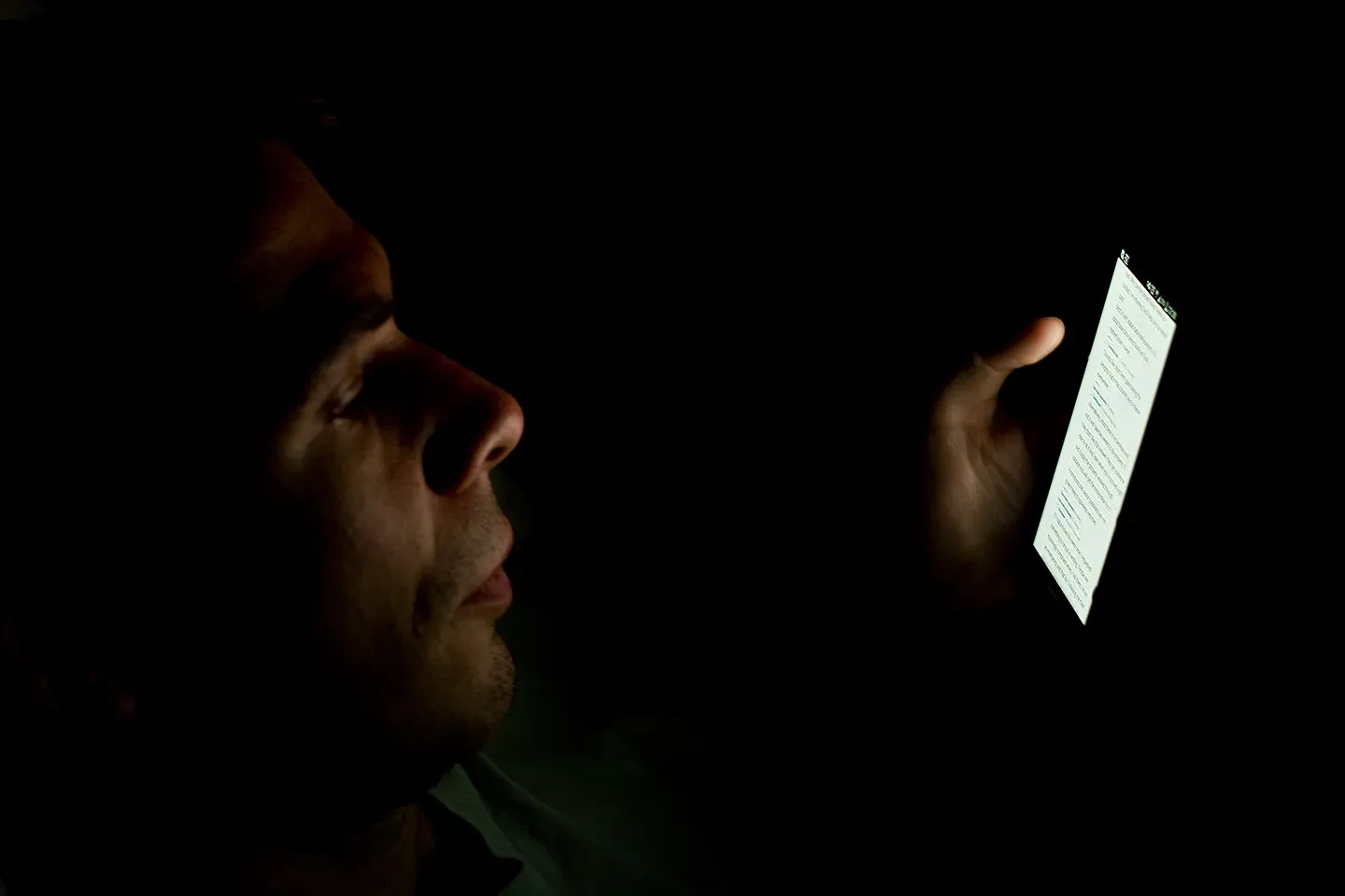 wajah disinari ponsel di ruangan gelap