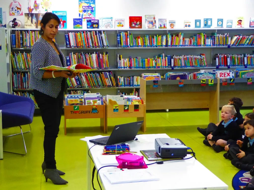 Pembacaan cerita di perpustakaan; anak-anak fokus mendengarkan