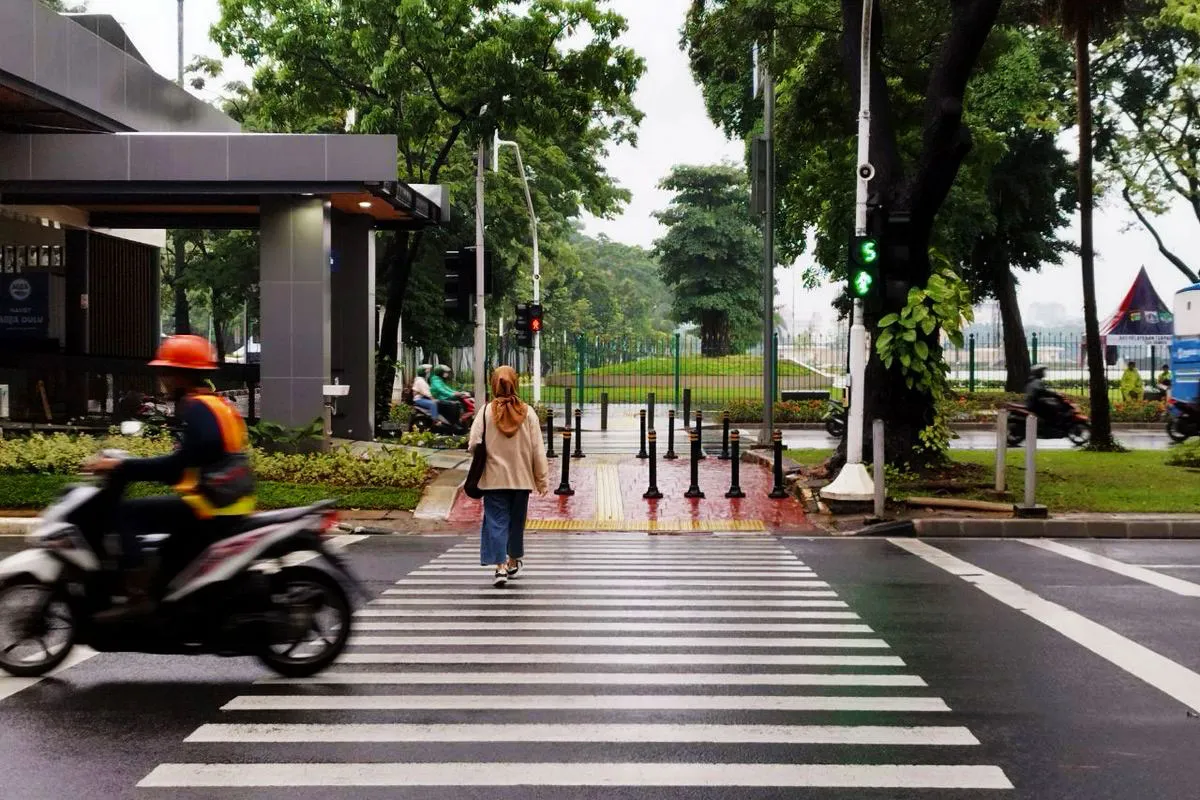 Gambar: Pejalan kaki melintasi zebra cross di jalan kota Indonesia