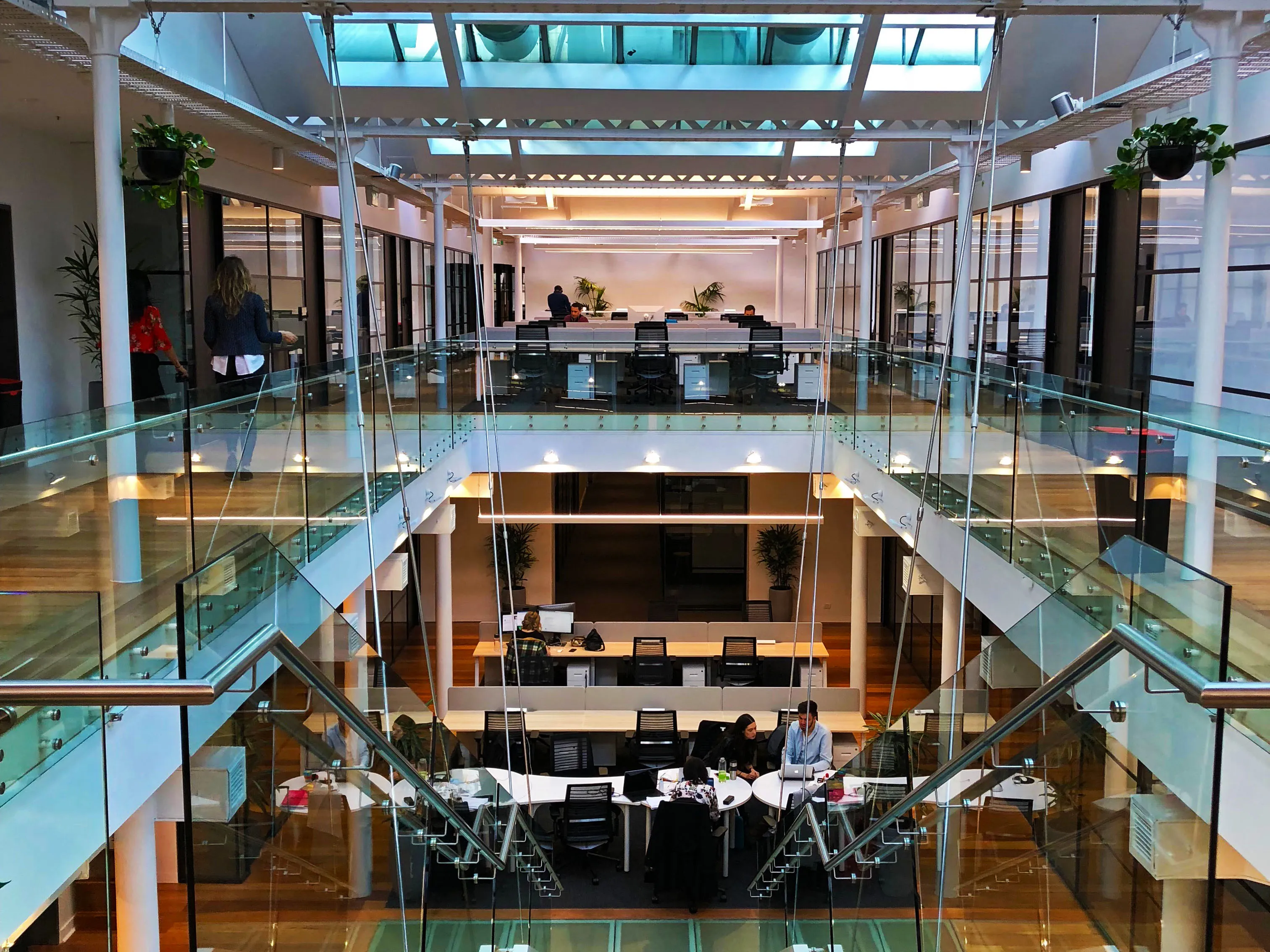 Area kerja bersama dengan meja panjang dan ruang kantor terbuka