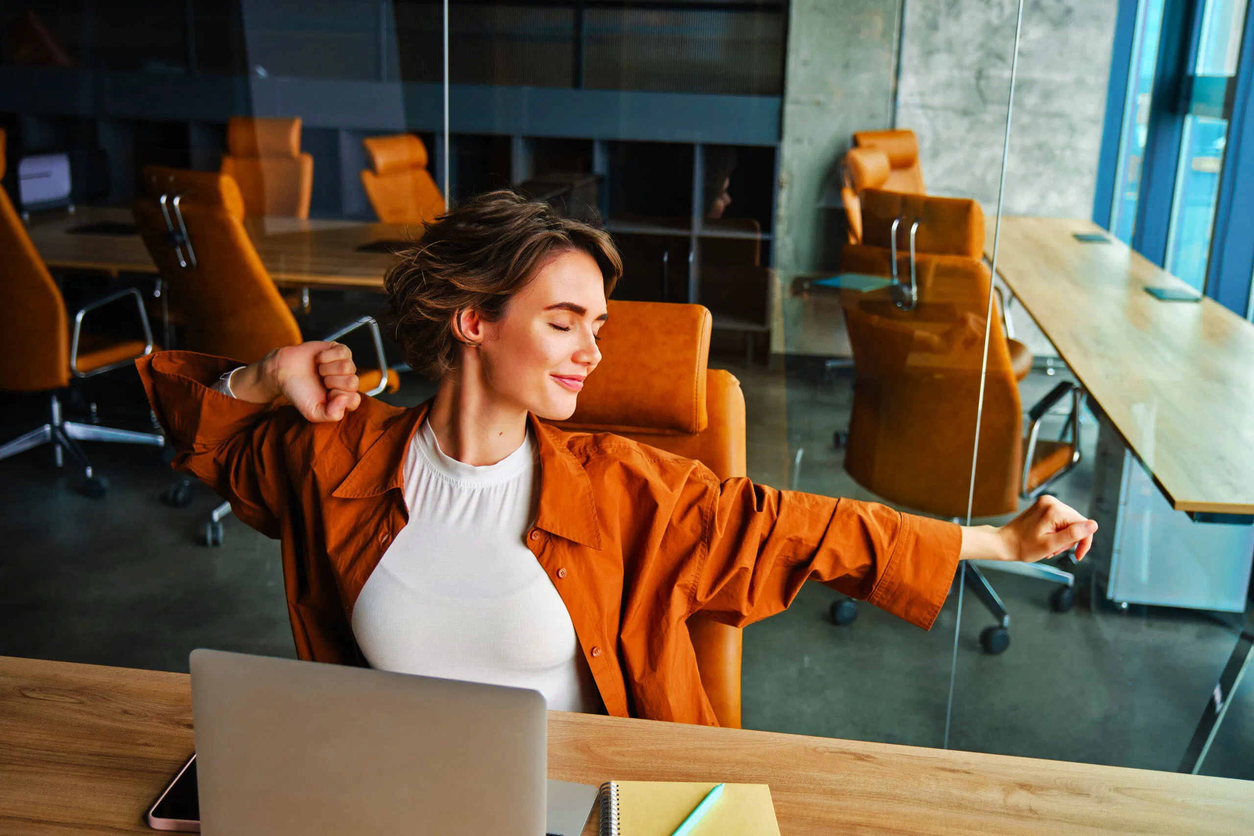 portrait woman resting office stretching arms after sitting working laptop