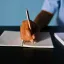 Tangan menulis dengan pulpen di atas kertas