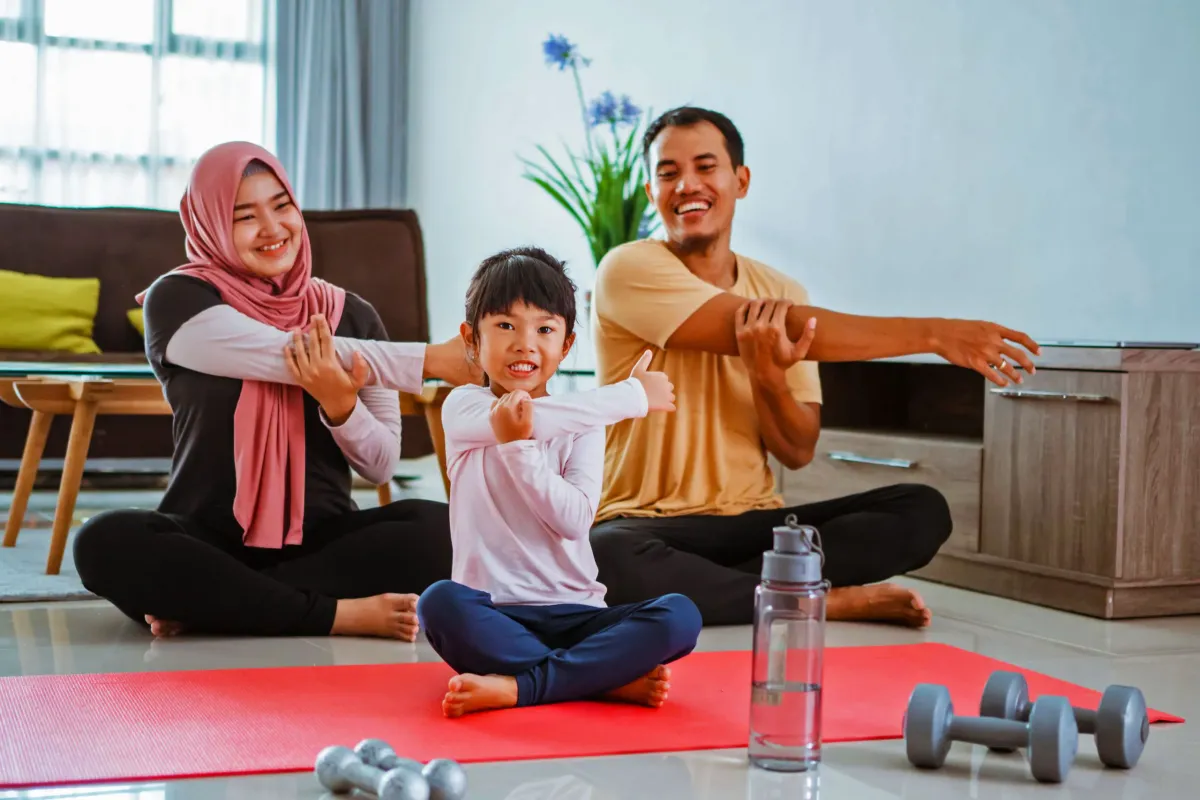 Keluarga Indonesia tersenyum bersama di ruang tamu rumah