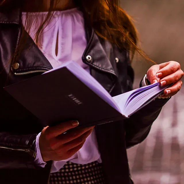 Perempuan membaca buku dengan santai