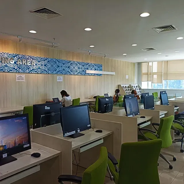 Area baca Perpustakaan Nasional RI—deretan meja, kursi, dan jendela besar yang terang