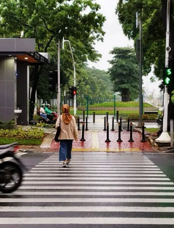 Pejalan kaki melintasi zebra cross di jalan kota Indonesia