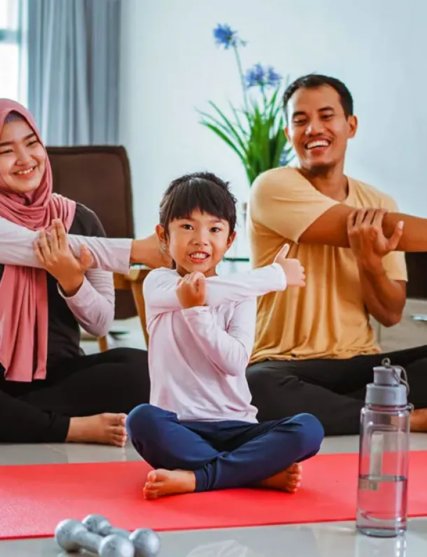 Keluarga Indonesia tersenyum bersama di ruang tamu rumah