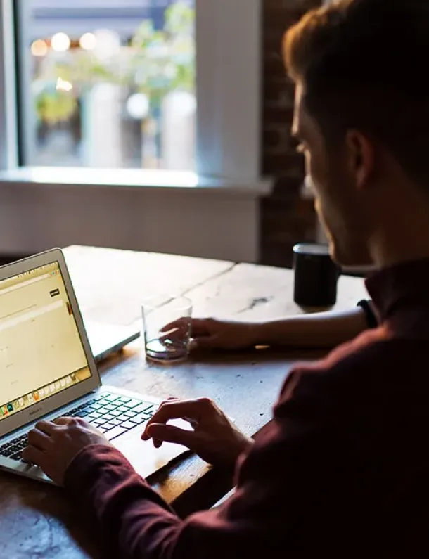 Pria bekerja fokus dengan laptop di meja kantor
