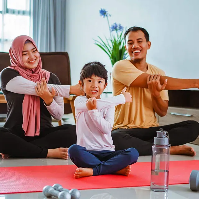 Keluarga Indonesia tersenyum bersama di ruang tamu rumah
